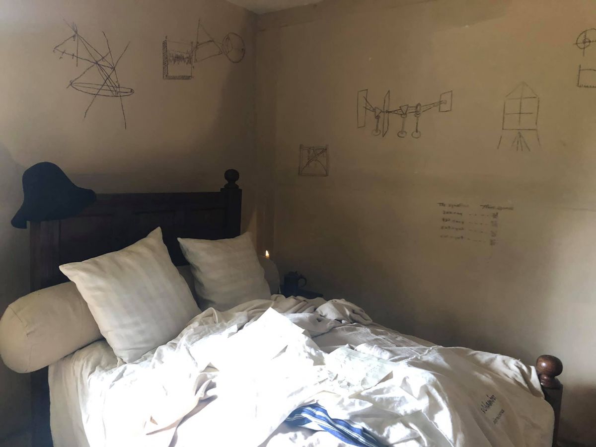 Isaac Newton's bedroom showing a bed and writing on the wall